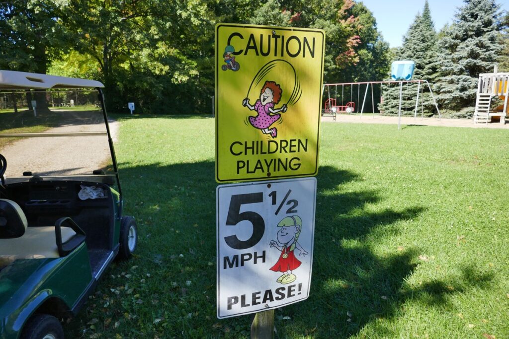 Caution kids playing sign with playground in background